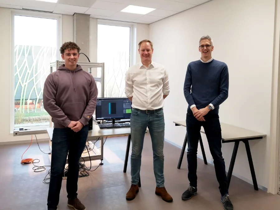 Teamleden van Deep Atlas en Researchable in een laboratoriumruimte met analysesoftware op een scherm, bij hun samenwerking rond gesteente-analyse