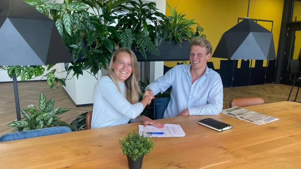 Nieuwe product owner Fionneke Bos schudt lachend de hand van een collega aan de overlegtafel bij Researchable
